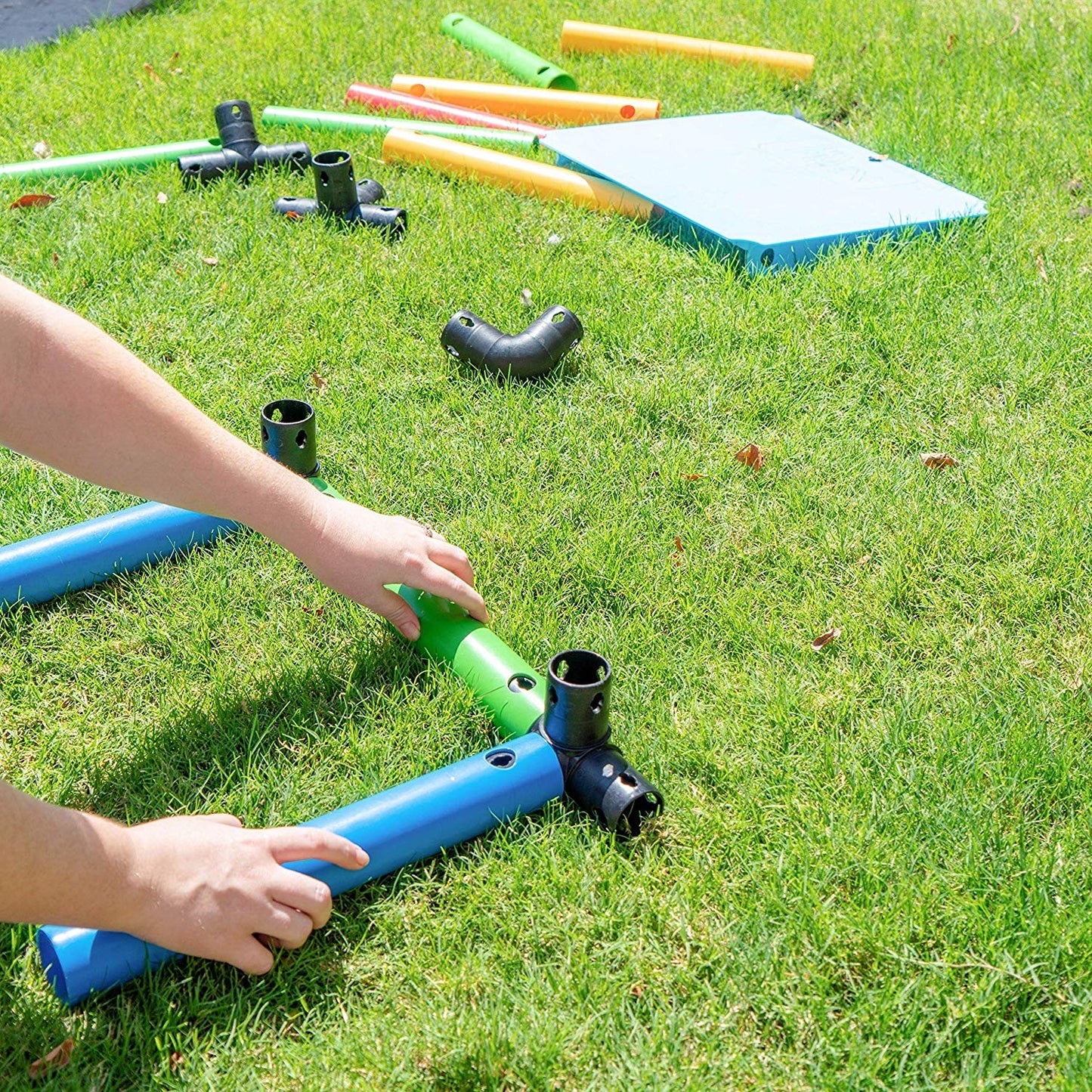 Funphix UK Standard Kit image showing a child assembling colourful toy components on grass, promoting outdoor play and creativity.