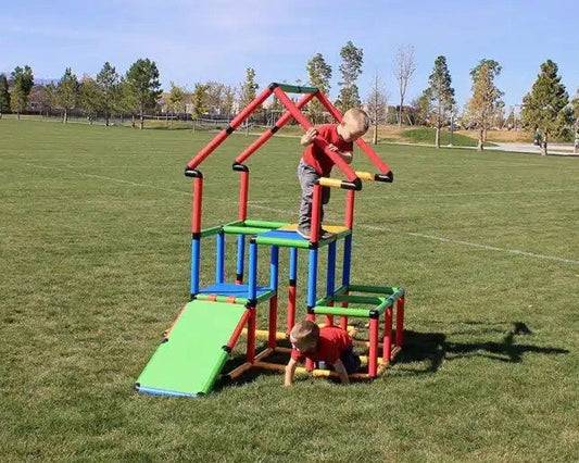 Kids playing on a Funphix UK Jumbo Kit playhouse in an outdoor park, showcasing imaginative structures and adventurous playtime.